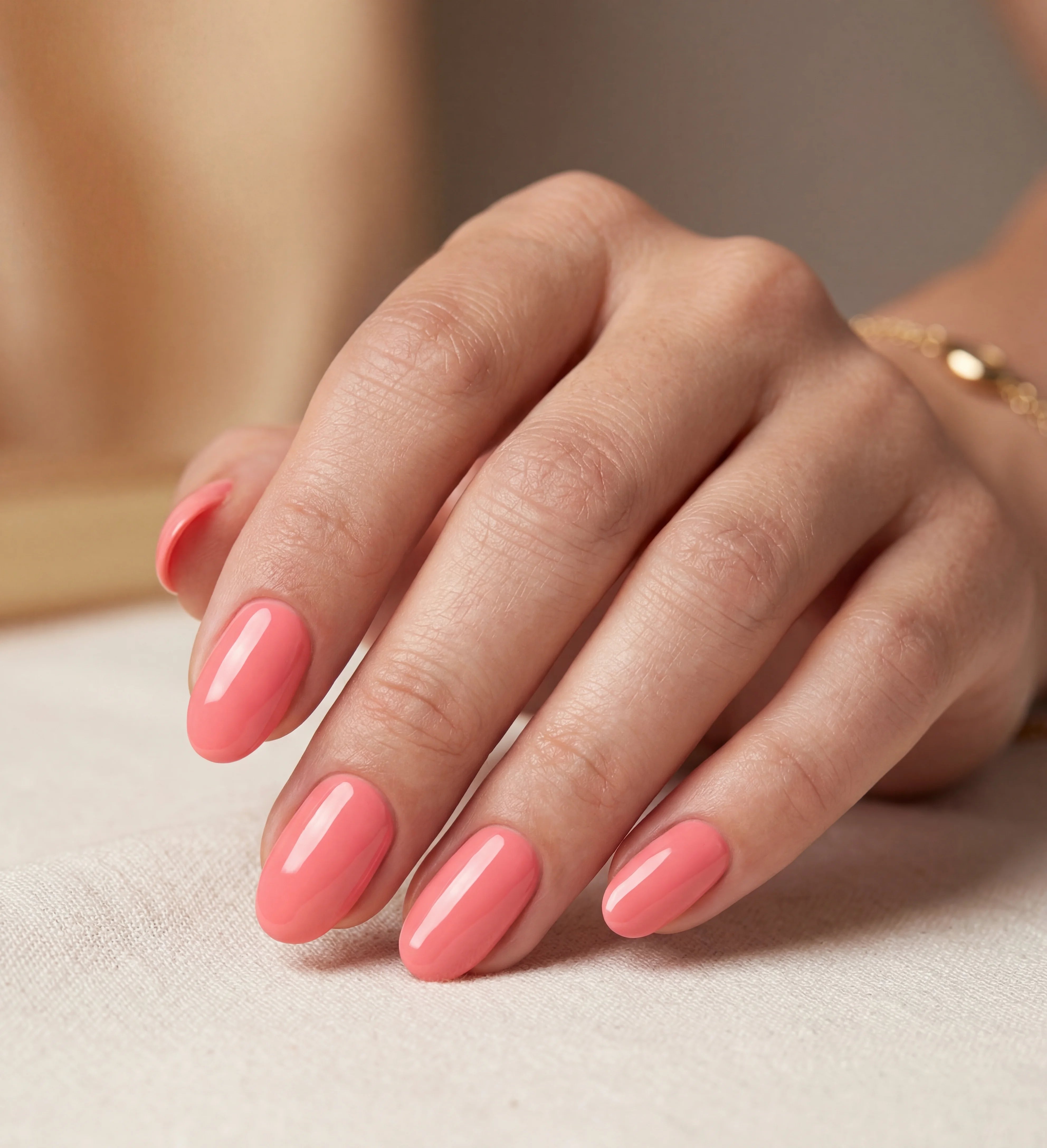 Hand with pink nail polish on a neutral background